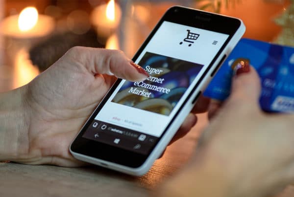 Hand auf einem Smartphone benutzt PrestaShop Onlineshop