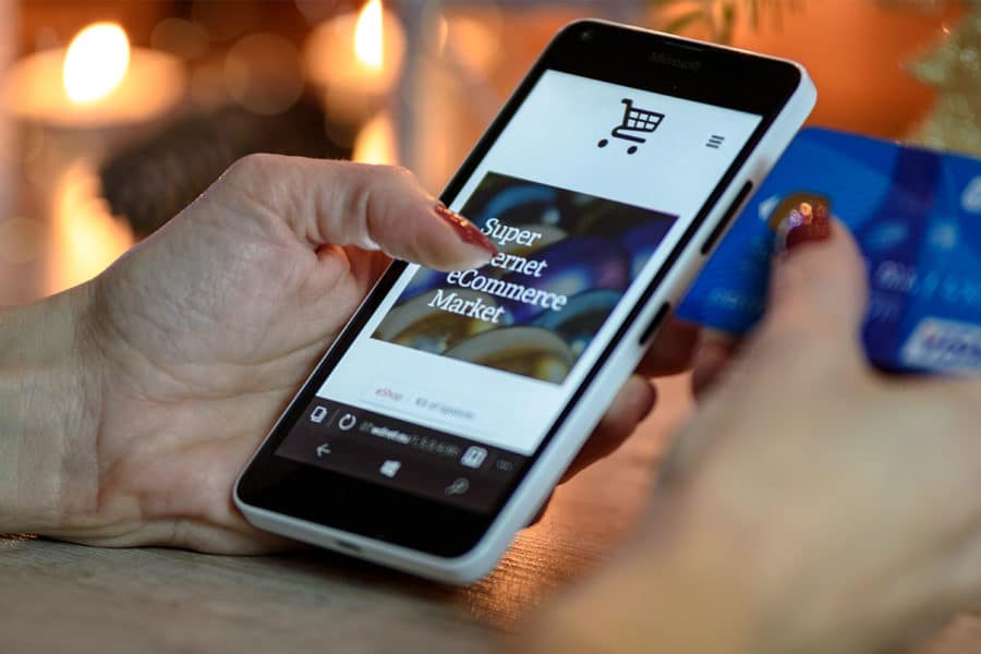 Hand auf einem Smartphone benutzt PrestaShop Onlineshop
